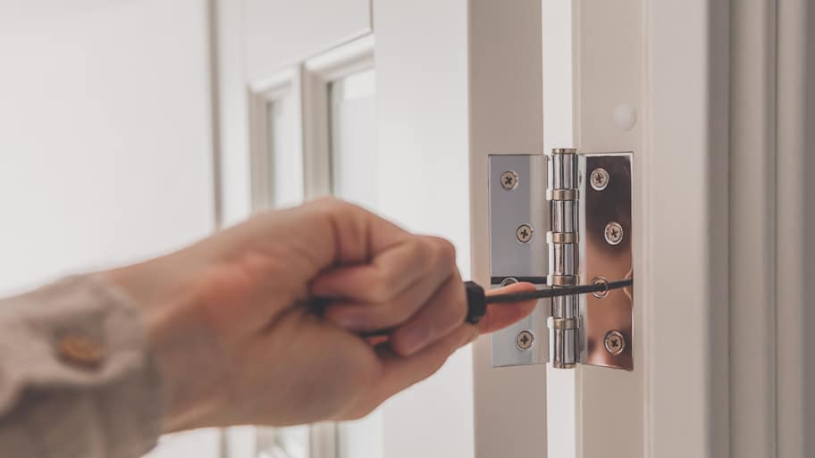 Man removing stainless door hinges 