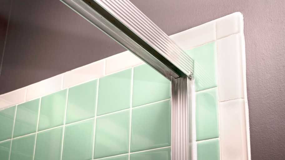 Shower door frame header attached to the wall