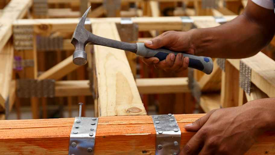 Man nailing wood flooring.