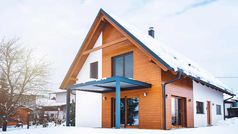 Modern house with a metal roof covered with snow