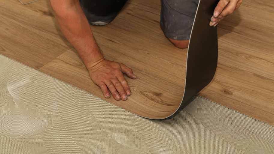 A man installing vinyl flooring