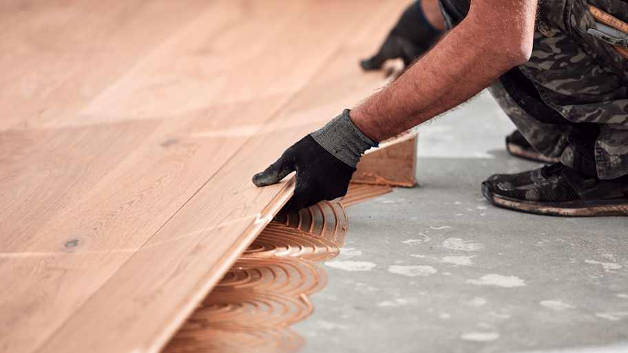 A person installing engineered hardwood flooring