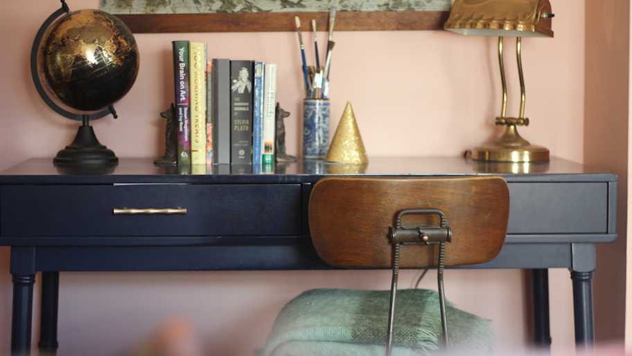 A vintage blue desk with an antique chair