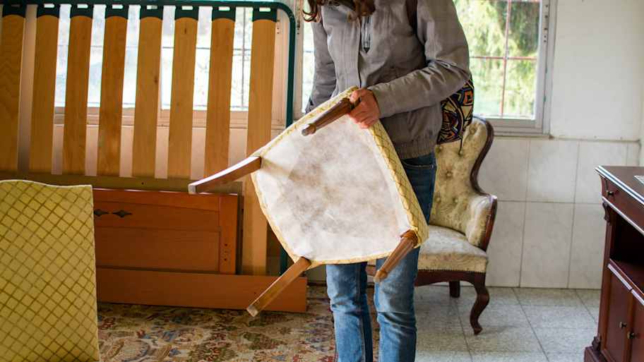 A woman examining a wooden chair