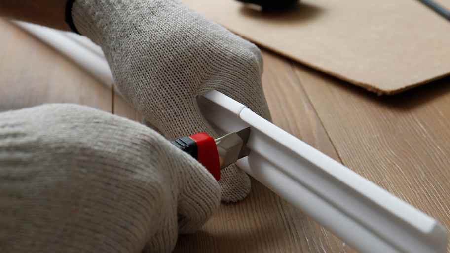 A person cutting a foam crown molding 