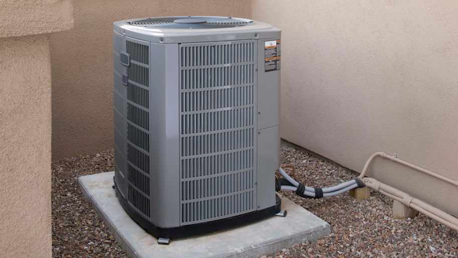 Central AC unit sitting on a concrete slab