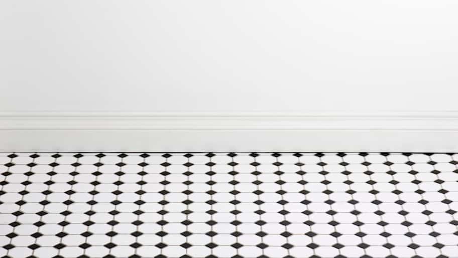 Bathroom with tile flooring and empty white wall 