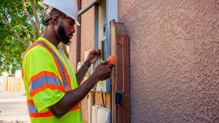 Worker checking outdoor electrical panel 