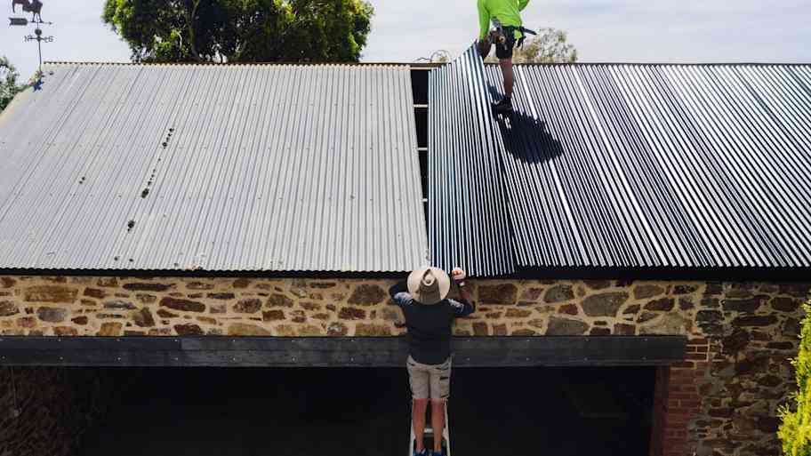 man installing metal roof