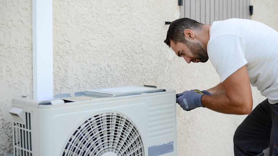 electrician installing ac unit outside