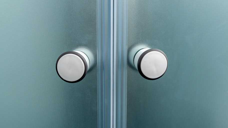 Close up of shower door knobs.