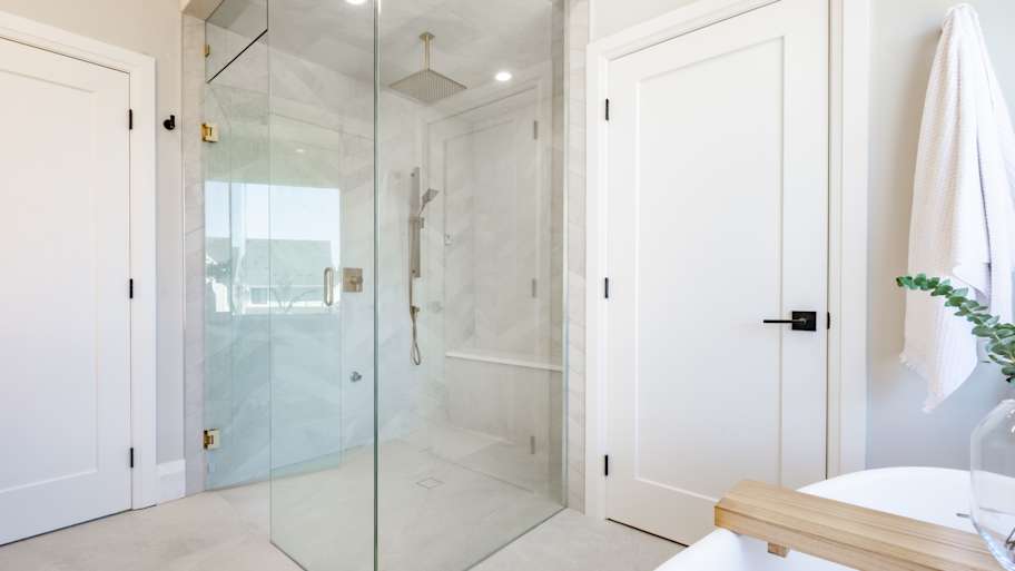 Elegant bathroom glass wall shower with black faucet fixtures and a small round black sink 