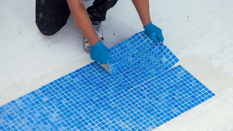 man laying pool tile