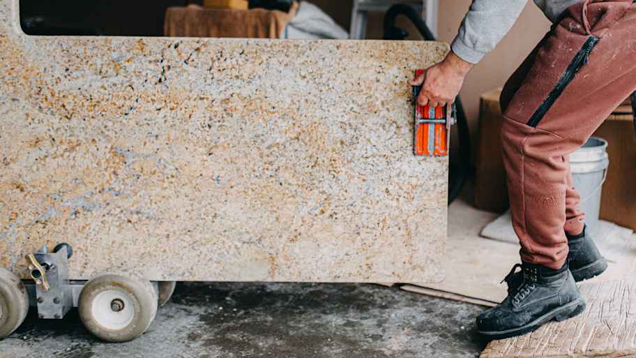 A professional moving a granite countertop
