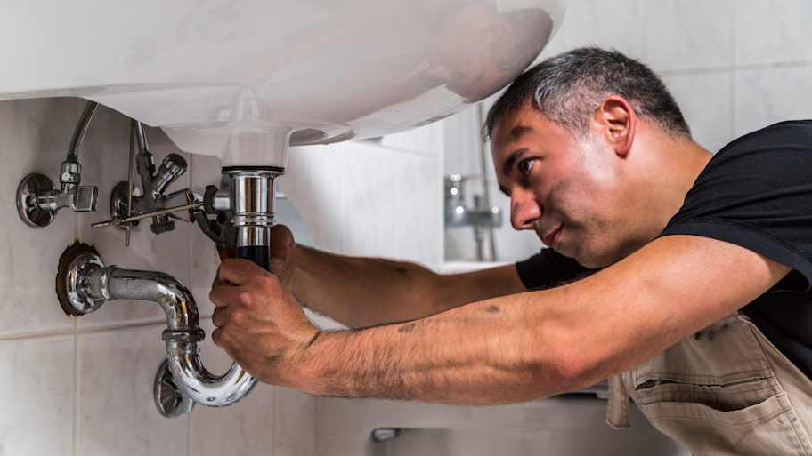 plumber fixing bathroom sink