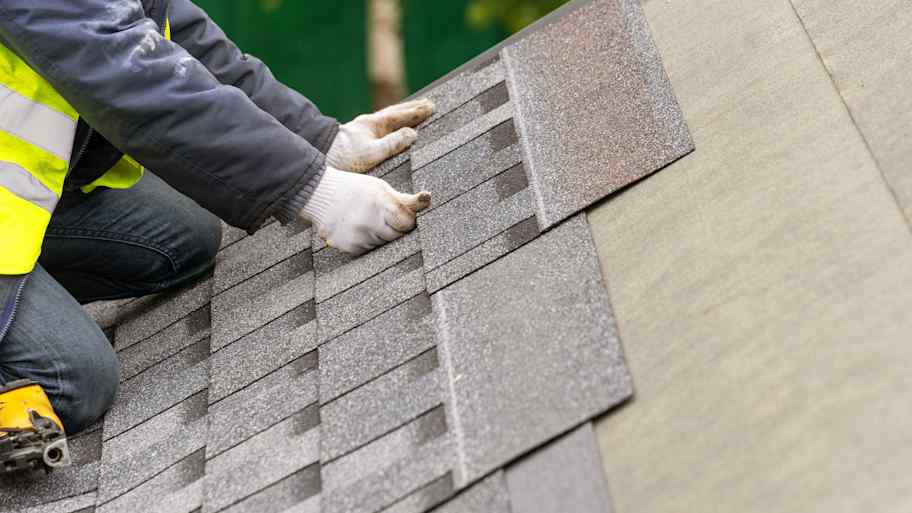 workman installing tile on roof  