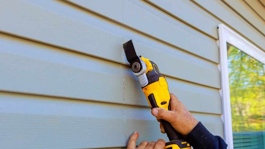 man repairing siding