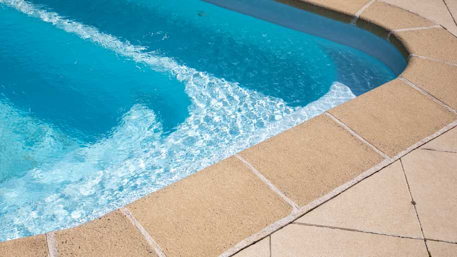The corner of a pool with visible pool liner and stairs to descend