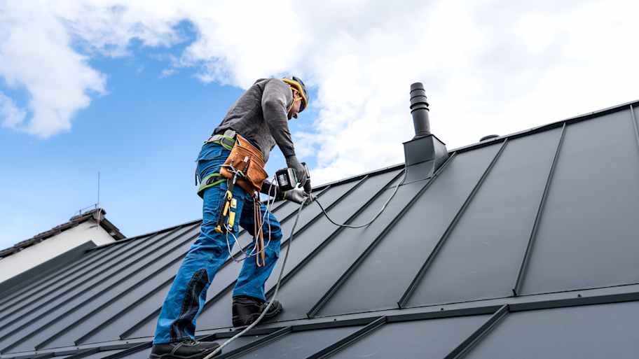 Roofer installing a standing seam metal roof