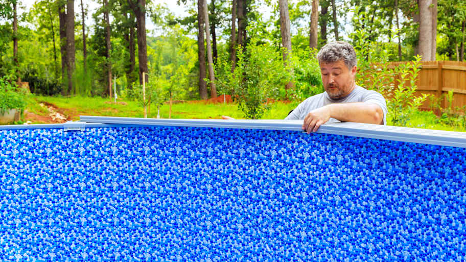 Worker installing pool liner in an above-ground pool