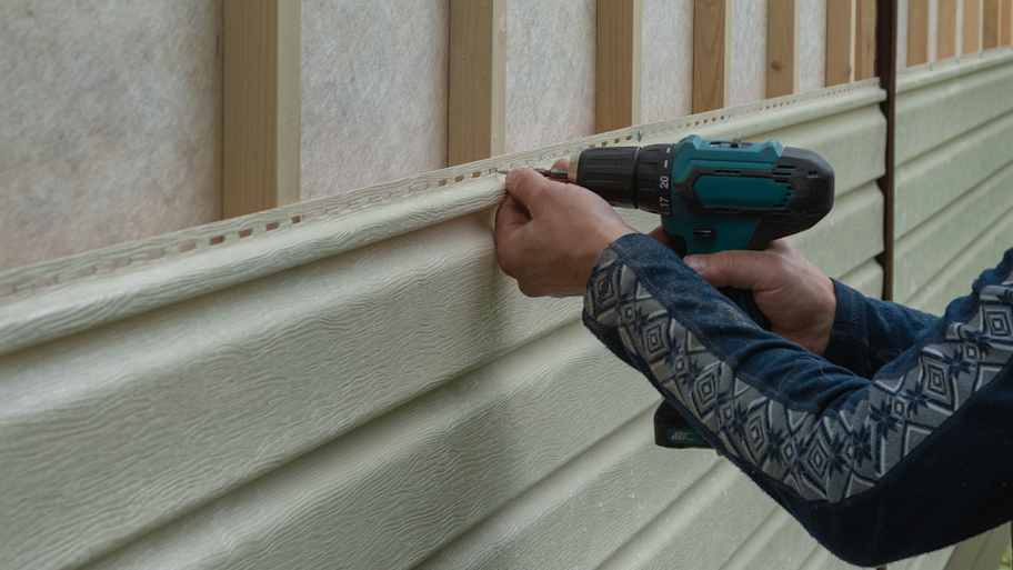 Worker installing siding panels