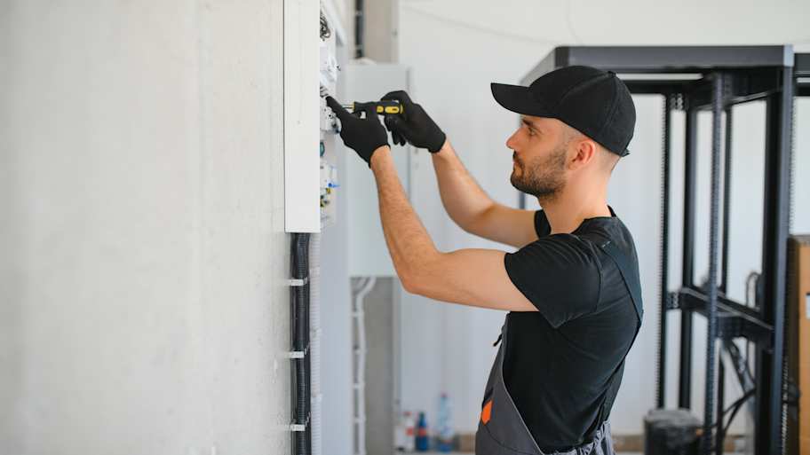 electrician testing switchboard fuses 