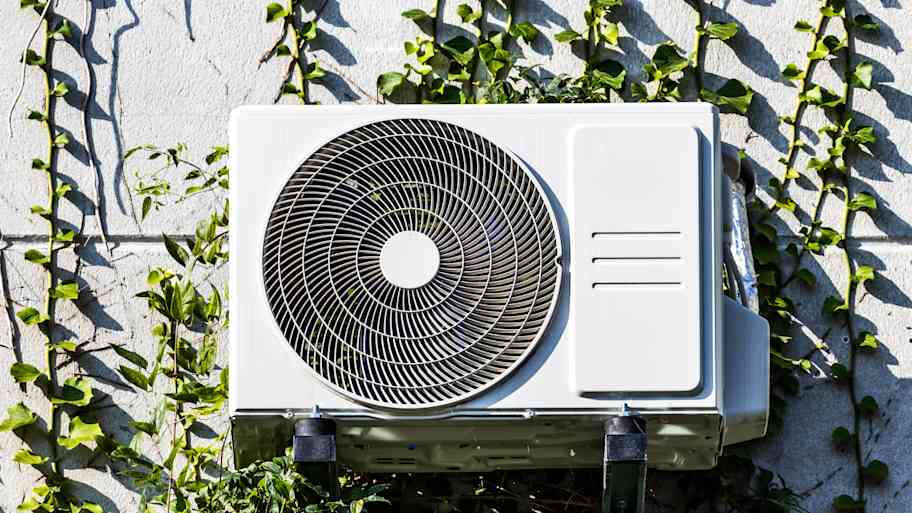 Heat pump on a facade with green plants 