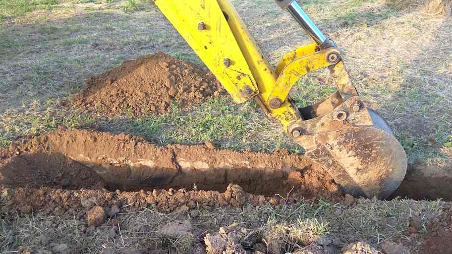 Excavator digging a trench for a main water line