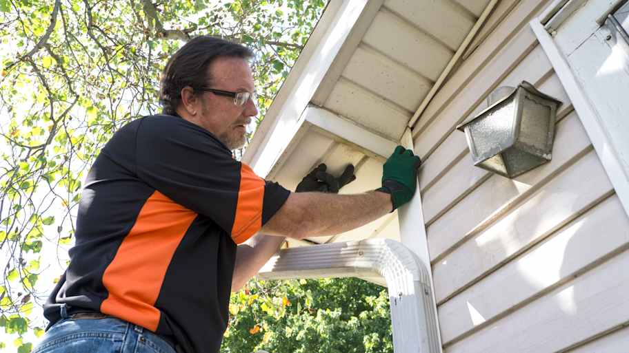 Contractor inspecting vinyl siding   