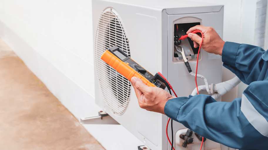 Technician repairing central air conditioning system 
