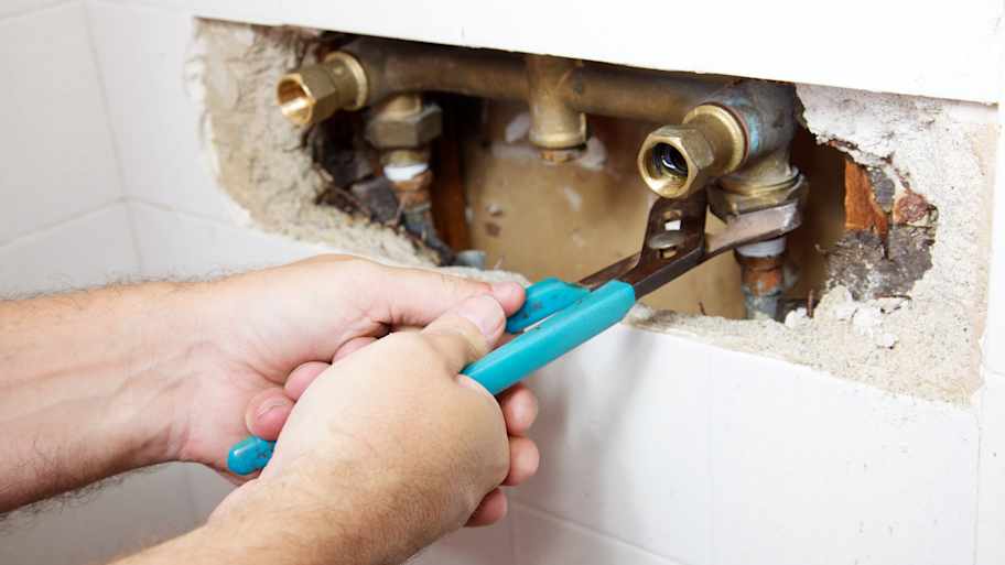 Plumber fixing broken pipe