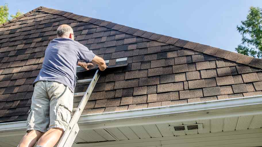 man repairing asphalt shingle roof 