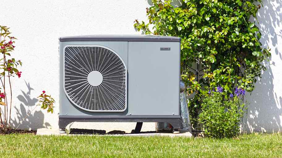 Heat pump sitting on a concrete slab in the yard  