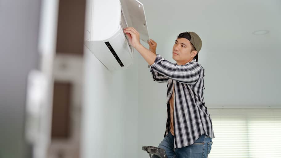 A person installing a ductless AC 