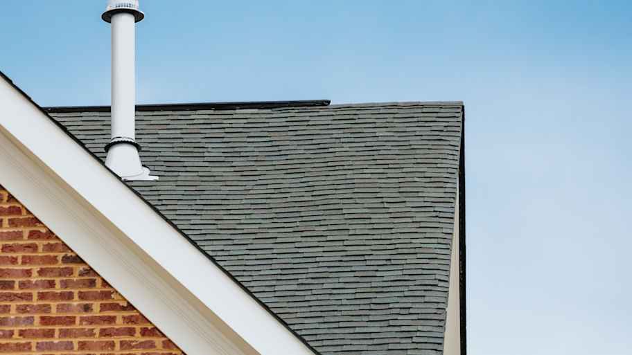 A roof with asphalt shingles on a brick house 