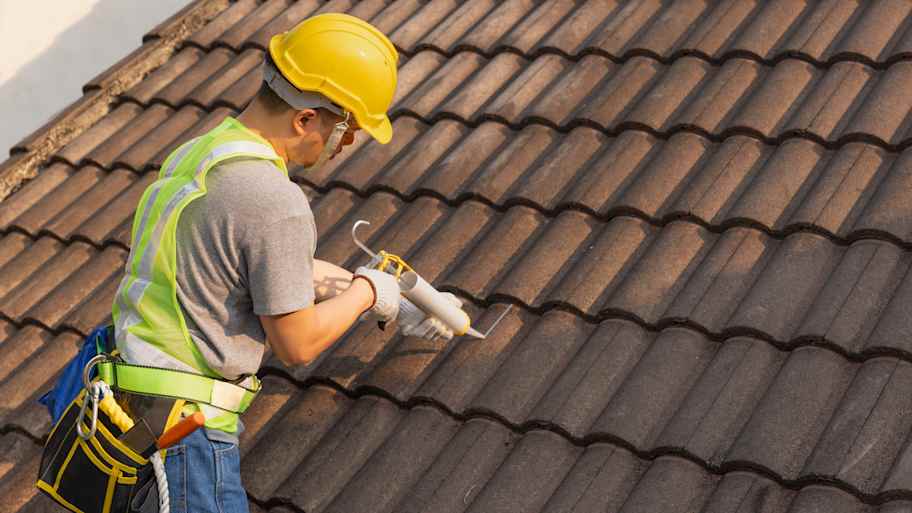 A professional working on repairing roof tiles 