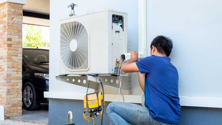 technician installing ac outside home