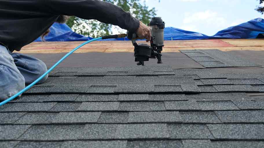 handyman installing shingle on roof