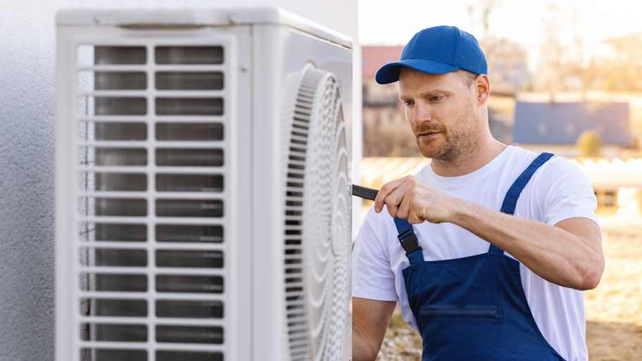 repairman fixing heat pump