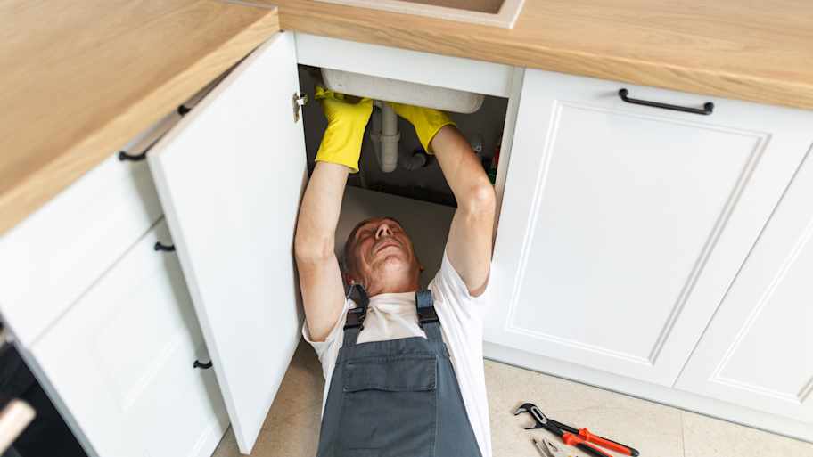 Plumber fixing the sink 