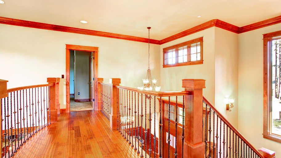 Loft with wood crown molding and an iron railing