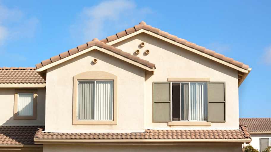 Windows installed on the upper level of a stucco house