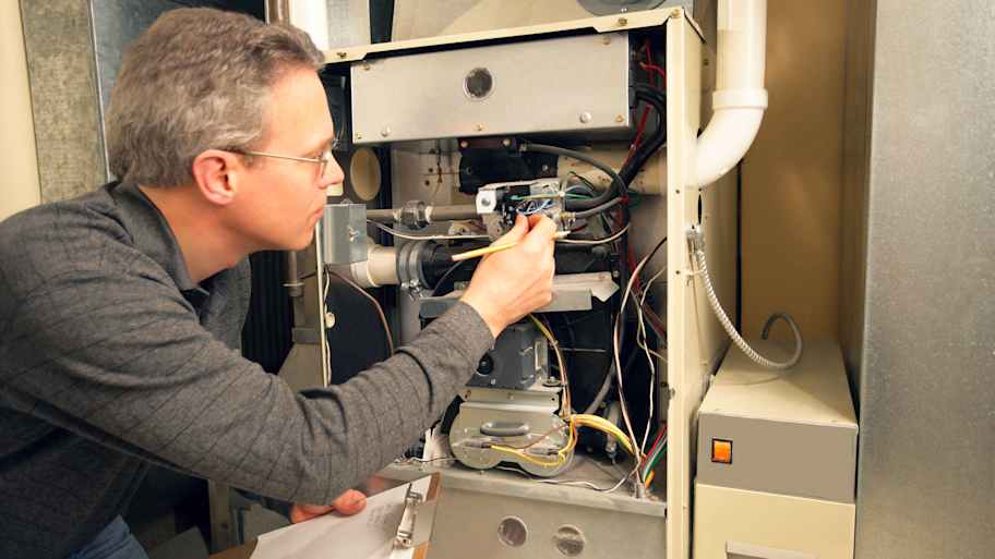 Technician inspecting the furnace in the basement   