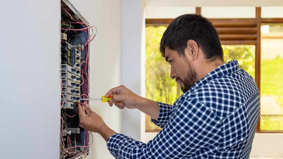 Electrician installing a fuse box 