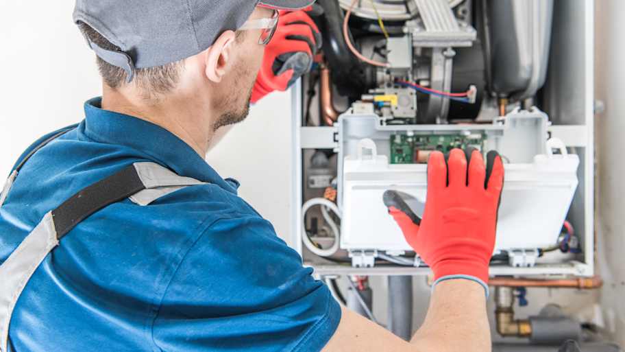 Technician fixing central gas furnace 