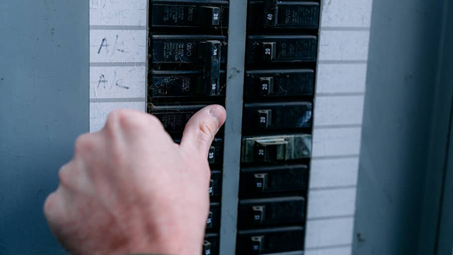 Man turning on a circuit breaker