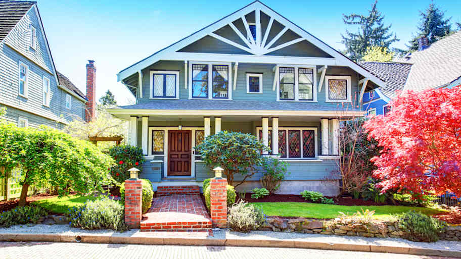 Craftsman style house with blue siding and a brick walkway   