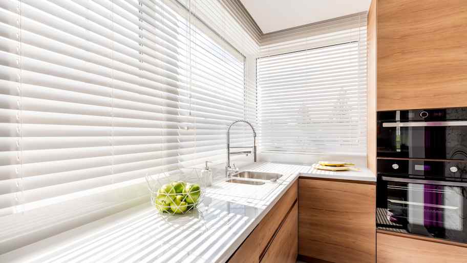 White mini blinds installed in a minimalist kitchen  