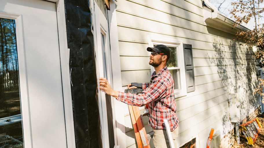 Construction worker repairing a colonial style house siding