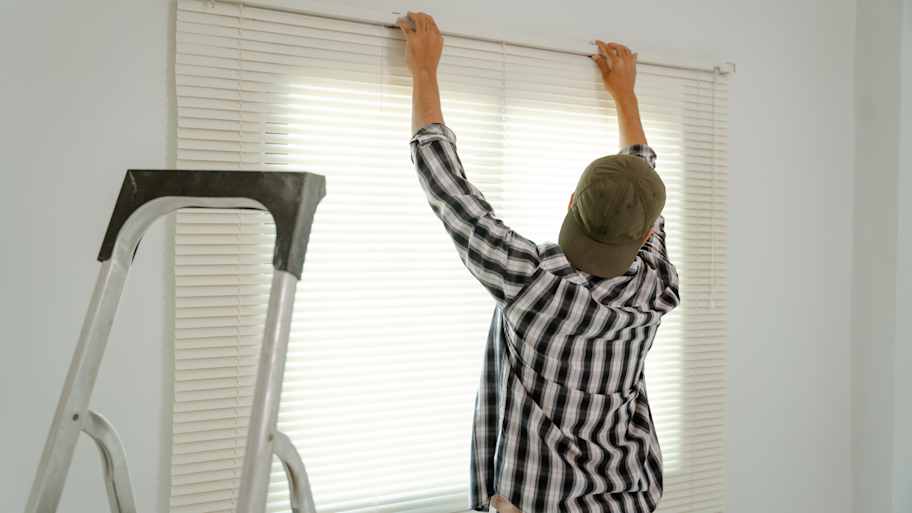 Worker installing blinds